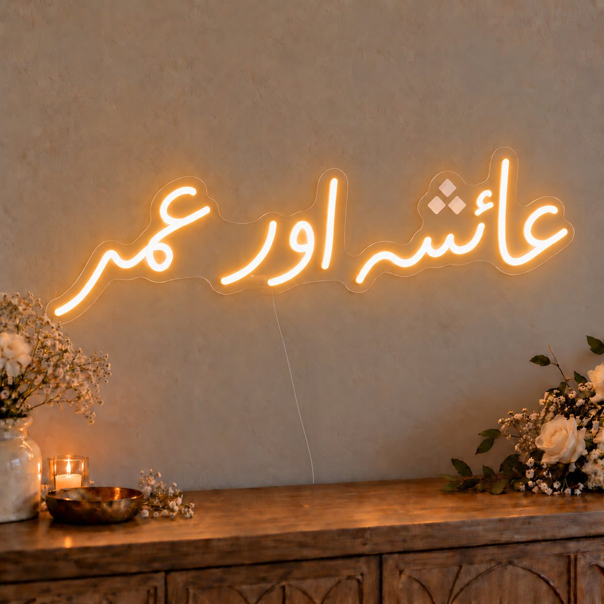 Urdu Couple Names Neon Sign on clear cut-to-shape acrylic, illuminated on a wall in a styled celebration setting; sample personalised wording shown
