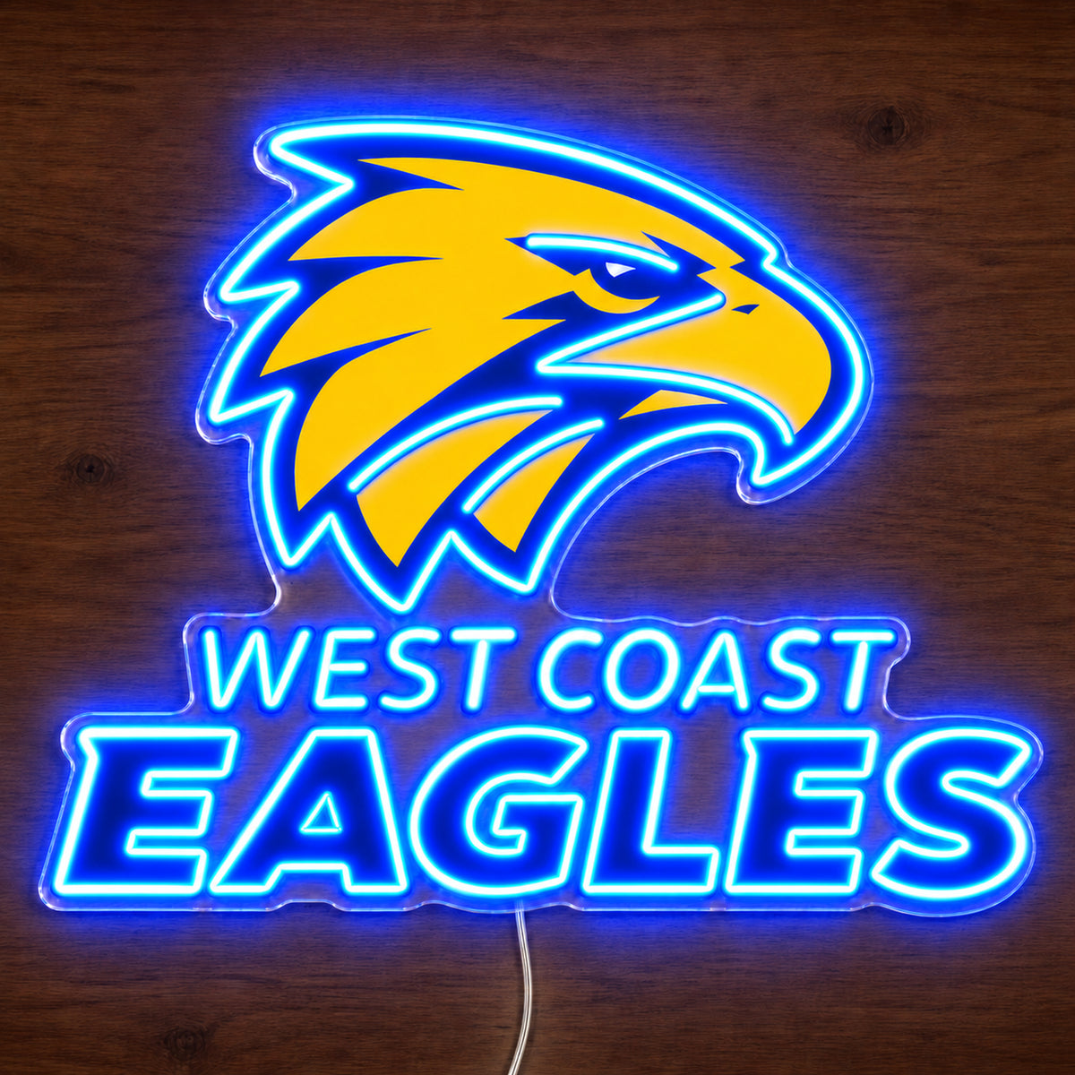 West Coast Eagles neon sign glowing brightly on a wooden surface in dim lighting